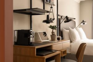 a bedroom with a desk with a coffee machine on it at 55 by Le Mirage in London