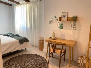 a bedroom with a bed and a table and a desk at AZUL PORTMÁN – DESIGNED FOR GROUP in Portman