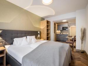 a bedroom with a large bed and a kitchen at Regina Hotelsuites in Sölden