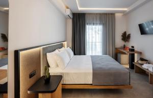 1 dormitorio con 1 cama grande y TV en Chora Suites, Premium Key Collection en Skíathos
