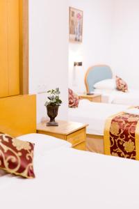 a room with three beds and a vase on a table at Villa Sri Mayang in Kuala Terengganu