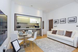 The Dorset Suite - Stylish New 1 Bedroom Apartment In Marylebone في لندن: غرفة معيشة مع أريكة بيضاء وطاولة