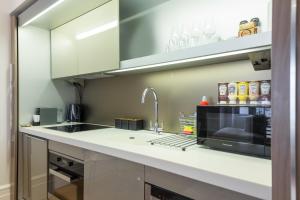 eine Küche mit einer Spüle und einer Mikrowelle in der Unterkunft The Dorset Suite - Stylish New 1 Bedroom Apartment In Marylebone in London