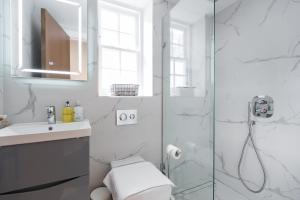 a bathroom with a shower with a toilet and a sink at The Dorset Suite - Stylish New 1 Bedroom Apartment In Marylebone in London