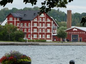 um grande edifício vermelho ao lado de uma massa de água em Hatty's Guesthouse em Motala