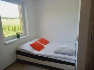 a small bed in a room with a window at Ojcowski Las in Biały Kościół