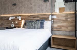 1 dormitorio con 1 cama y pared de madera en Luxury Apartment In The Heart of Leicester With Parking, en Leicester