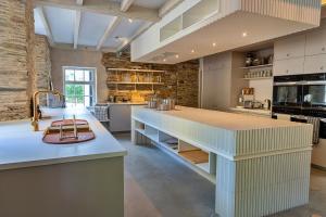 a large kitchen with a large island in the middle at Finest Retreats - The Half-ARC of Padstow in St. Issey