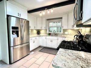 uma cozinha com armários brancos e um frigorífico de aço inoxidável em The Best Family & Friends Hangout & Pet Friendly!! em Wilmington
