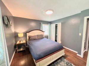 a bedroom with a bed and a lamp and a window at The Best Family & Friends Hangout & Pet Friendly!! in Wilmington