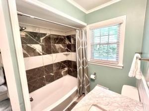 uma casa de banho com uma banheira e uma janela em The Best Family & Friends Hangout & Pet Friendly!! em Wilmington