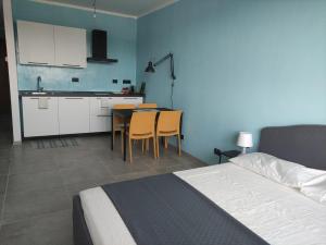 a bedroom with a bed and a kitchen with a table and chairs at Una finestra su Savona in Savona