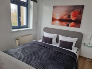 a bedroom with a bed with two pillows and a painting at Hotel Kreuzbergbaude beim Berzdorfer See in Görlitz