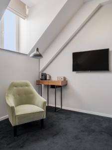 uma sala de estar com uma cadeira e uma televisão em numa l Lief em Bruxelas