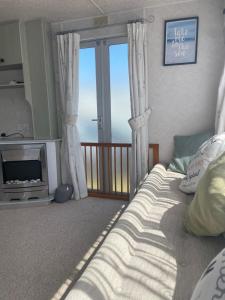 a bedroom with a bed and a view of the ocean at Hollie’s Hemsby holidays - static caravan in Hemsby