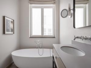 a white bathroom with a tub and a sink at numa l Lief in Brussels