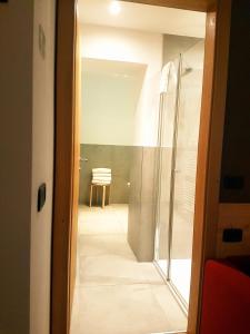 a bathroom with a shower and a glass door at Ciasa Alpina Relax Hotel in Moena