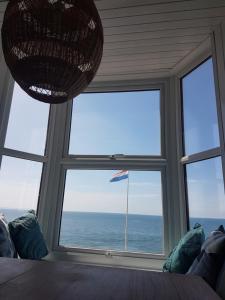 a room with a large window with a view of the ocean at Lovely Seafront 2 bed flat in Aberystwyth in Aberystwyth