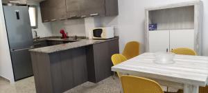 a kitchen with a counter and a table with yellow chairs at Ca Vicent in Calpe