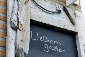 ein Schild in einem Holzrahmen in einem Gebäude mit einer Tafel in der Unterkunft Sleeping by Van Beelen in Katwijk