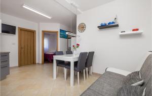 ein Wohnzimmer mit einem Tisch, Stühlen und einem Sofa in der Unterkunft Cozy Apartment In Povljana With Lake View in Povljana