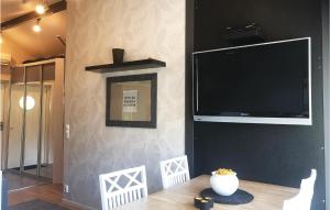 einen Flachbild-TV an einer Wand mit einem Tisch in der Unterkunft Beautiful Home In Henn With Kitchen in Henån