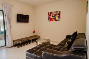 a living room with a couch and a tv at Best quality 2-bedroom apartment 2 km from Eagle beach in Palm-Eagle Beach