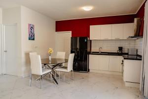 a kitchen with a table and chairs and a black refrigerator at Best quality 2-bedroom apartment 2 km from Eagle beach in Palm-Eagle Beach