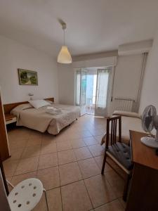 a bedroom with two beds and a table and a chair at Hotel Riz in Finale Ligure