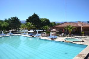 uma grande piscina com espreguiçadeiras e uma casa em Colina del Valle em Mina Clavero