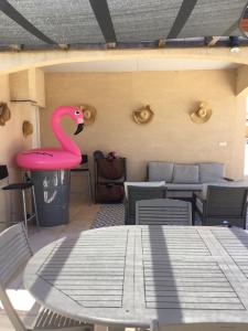 un flamingo rose assis sur une table dans une pièce dans l'établissement Douceur d été, à Saint-Sylvestre-sur-Lot