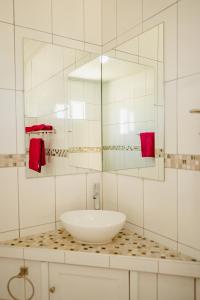 a white bathroom with a sink and a mirror at Best quality 2-bedroom apartment 2 km from Eagle beach in Palm-Eagle Beach