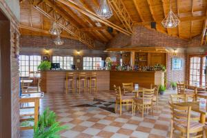 un ristorante con soffitti e tavoli in legno e sedie di Colina del Valle a Mina Clavero