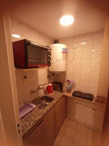 a small kitchen with a sink and a microwave at Departamento céntrico ciudad Mendoza in Mendoza