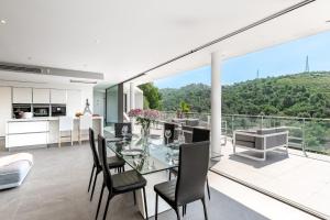 eine Küche und ein Esszimmer mit einem Glastisch und Stühlen in der Unterkunft Villa des Oliviers in Nizza