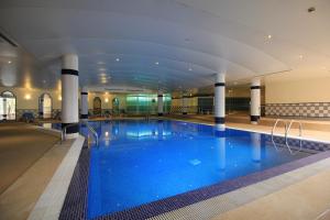 
a large swimming pool in a large room at Suite Hotel Jardins Da Ajuda in Funchal
