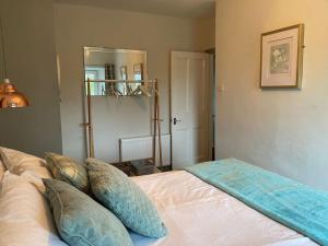 a bedroom with a bed with pillows and a mirror at No 8 Snowdonia. 3 Bedroom, sleeps 5. Pets accepted in Blaenau-Ffestiniog