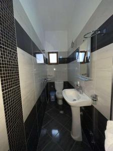 ein Bad mit einem Waschbecken und einem WC in der Unterkunft Vila Ronaldo in Ksamil