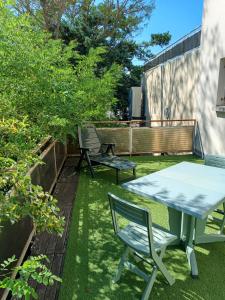 d'une terrasse avec une table et des chaises sur gazon. dans l'établissement Terrace Flat Near The City Centre, à Brives-Charensac