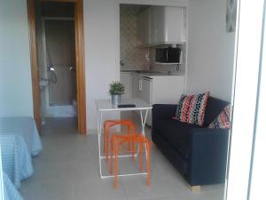 a living room with a couch and a table and chairs at El Jardin BeNerja in Nerja