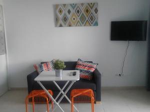 a living room with a couch and a table with chairs at El Jardin BeNerja in Nerja