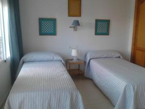 two twin beds in a room with at El Jardin BeNerja in Nerja