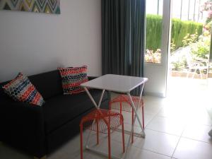 a living room with a couch and a table and stools at El Jardin BeNerja in Nerja