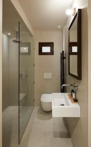 a bathroom with a sink and a toilet and a shower at The Storyteller Boutique House in Kalabaka