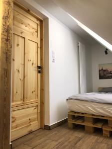 1 dormitorio con 1 cama y puerta de madera en Nowe miasto en Wałbrzych