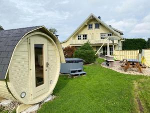 a large yellow house with a large yard with a shed at Haus Norway Oslo in Wittenbeck