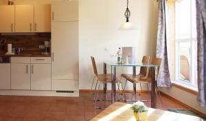 a kitchen with a table and chairs in a room at Haus Norway Oslo in Wittenbeck