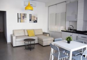 a living room with a couch and a table and chairs at El Jardin BeNerja in Nerja