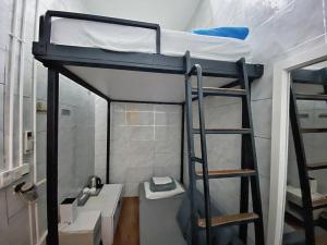 łóżko piętrowe w łazience z umywalką i drabiną w obiekcie K Hotel Aliwal (Premier) w Singapurze