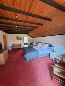 um quarto com uma cama e um tecto de madeira em B&B Am Sahrbach em Altenahr